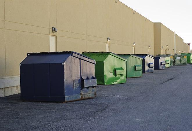 construction workers toss wood scraps into a dumpster in Annandale